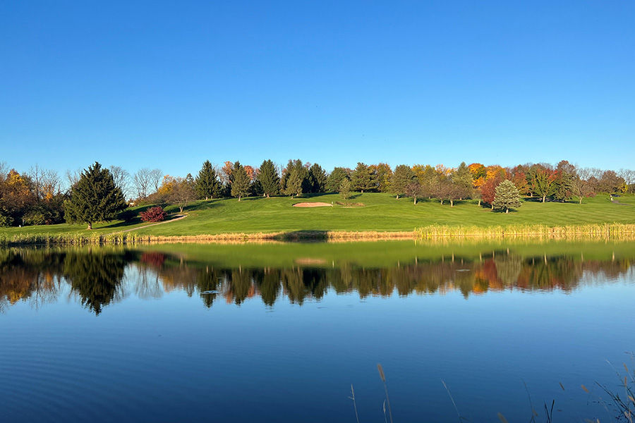 KemperSports golf course, Spring Hollow. A view of the pond, golf course and trees with fall colors.